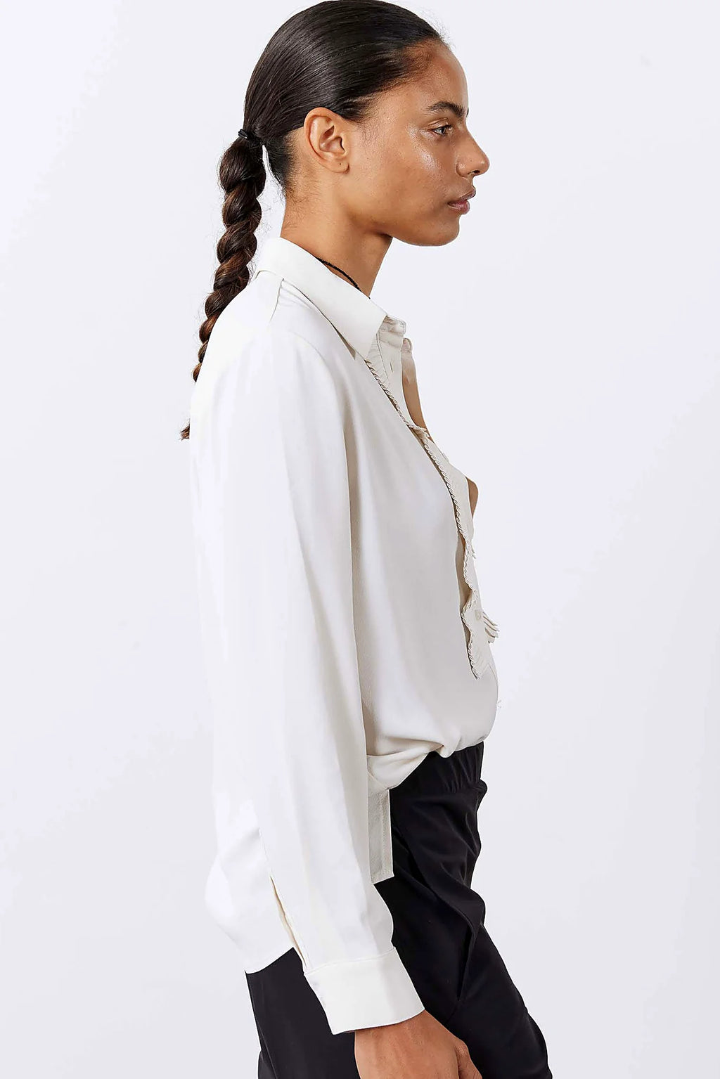 The relaxed drape and elongated hem of the blouse
